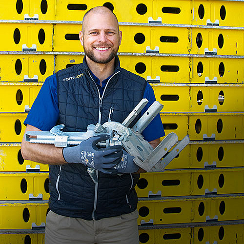 Christoph mit gebrauchten Schalungselementen in der Hand